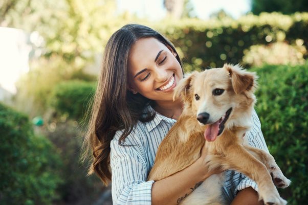Happy woman hugging her ESA dog outdoors, sharing a moment of love and bonding.