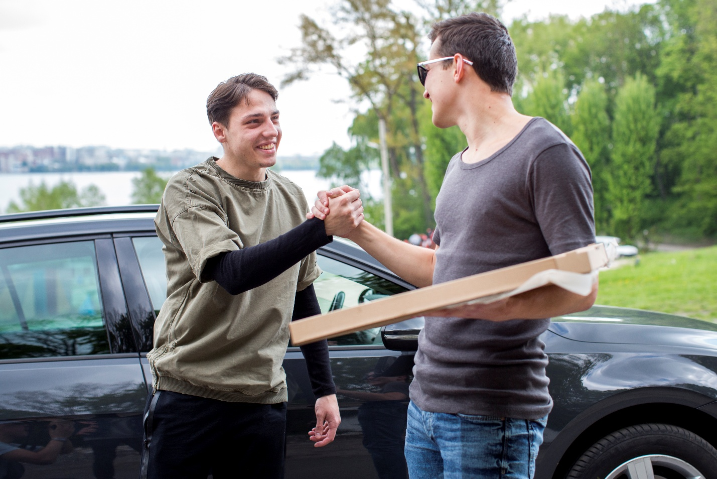 2 men in front of car