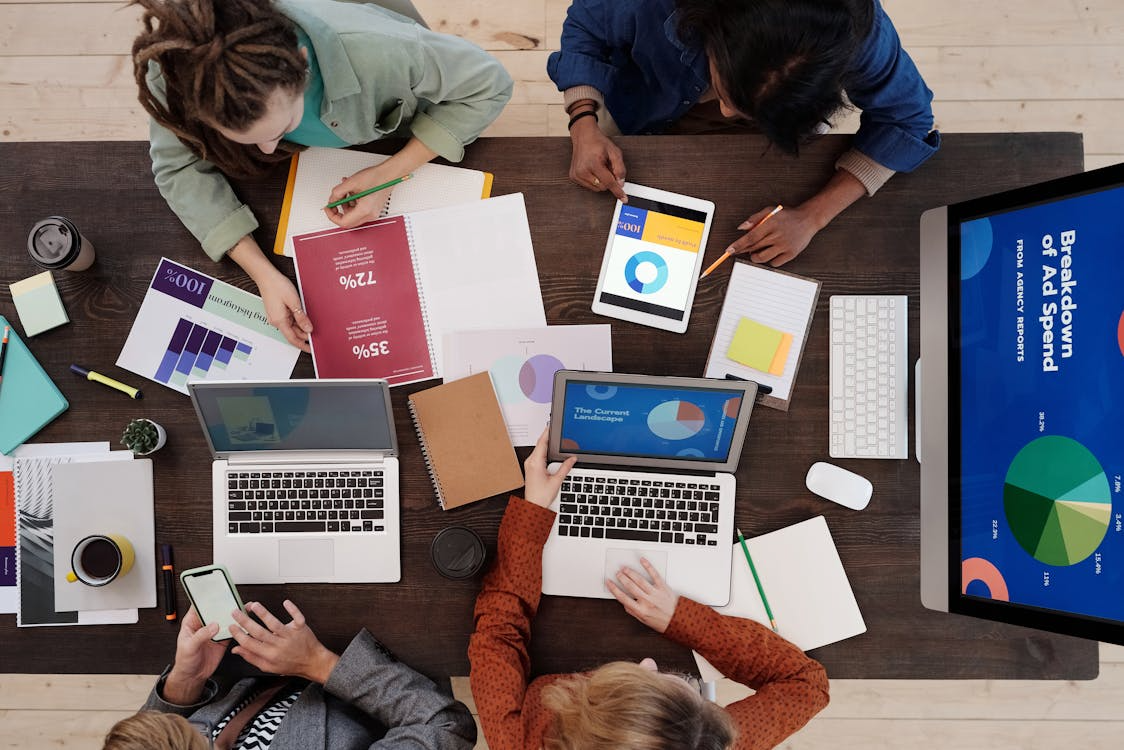 4 people with Laptops on a work desk