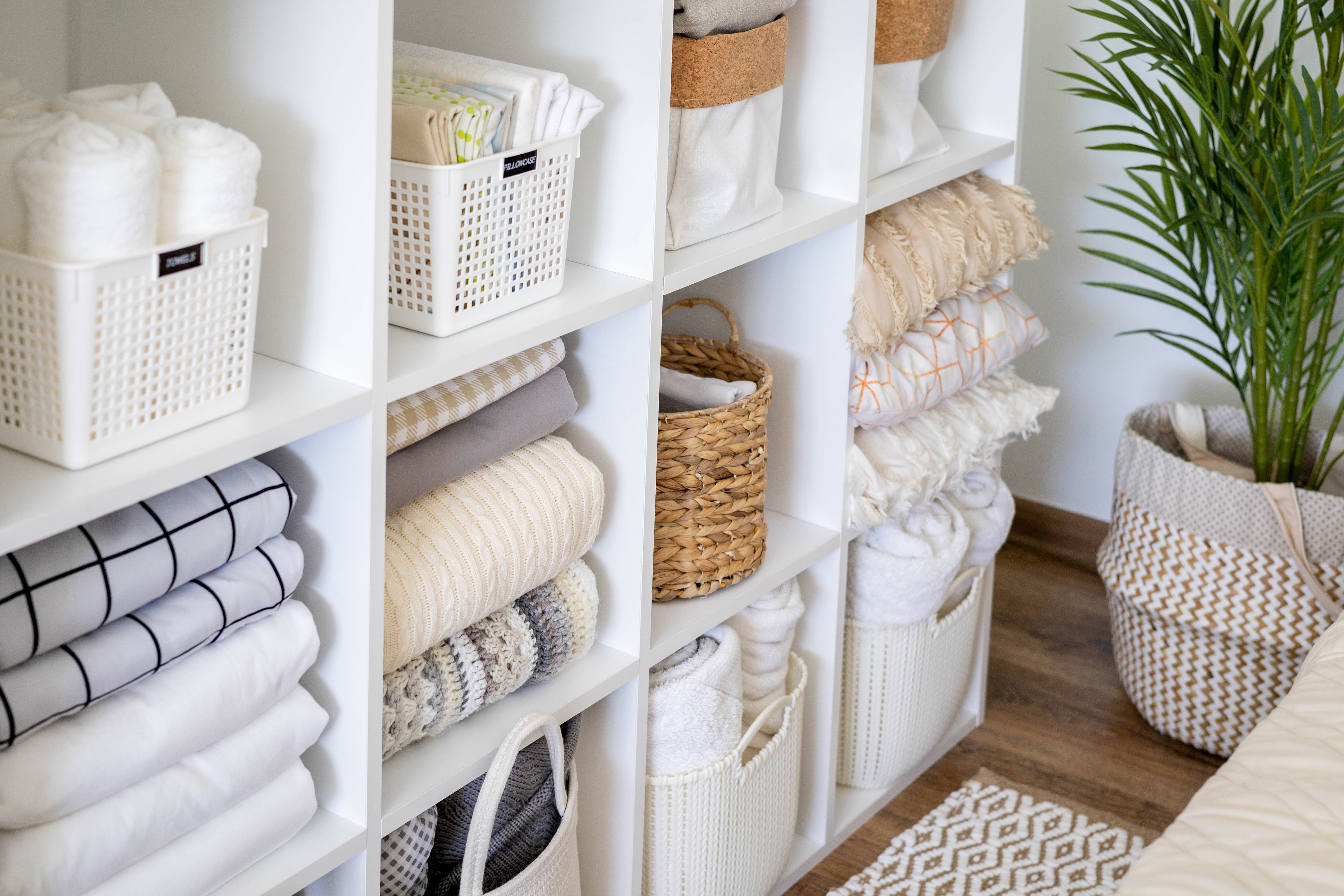 Neatly organized storage shelves with folded linens and baskets.
