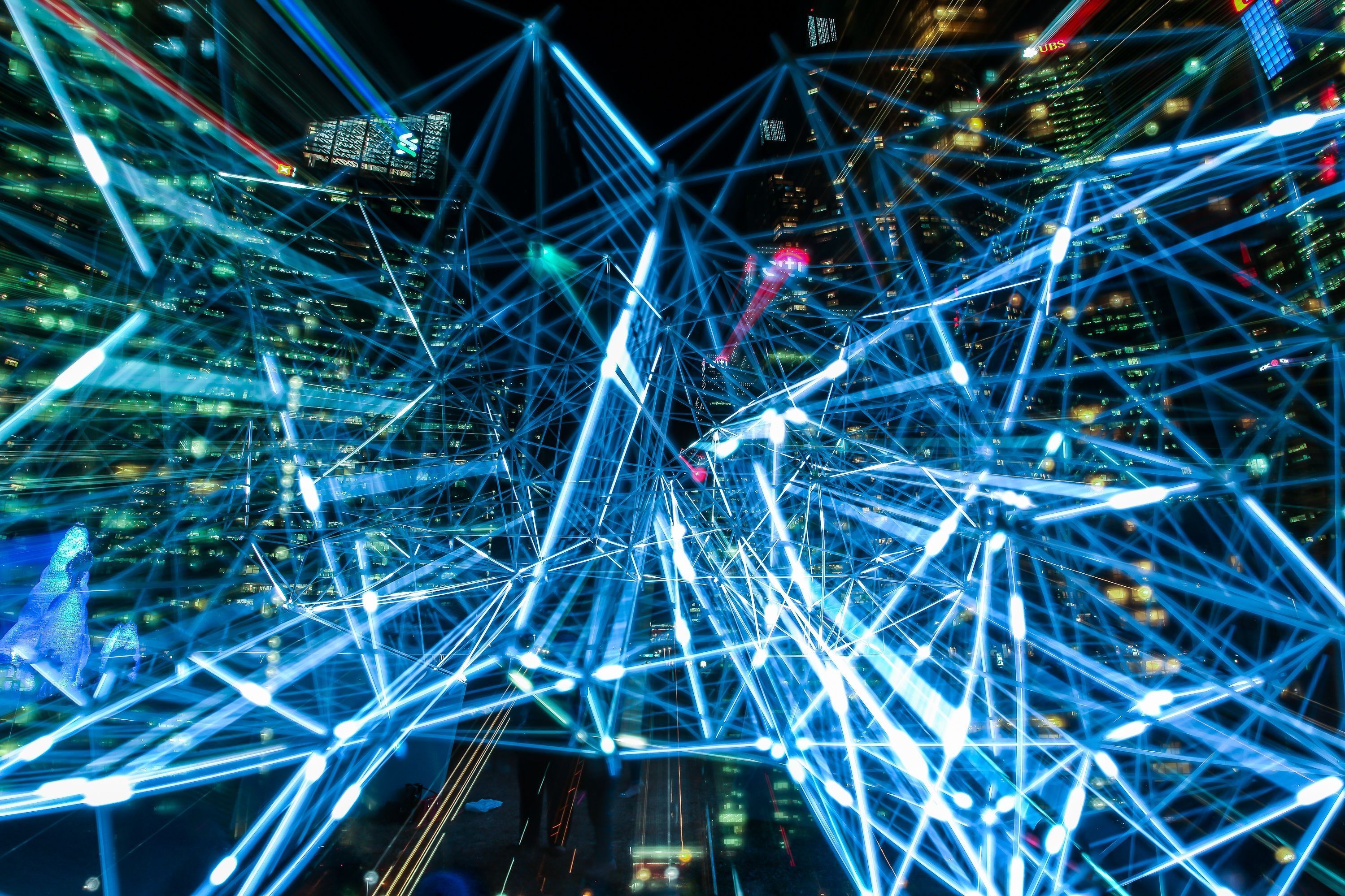 A dynamic urban scene showing interconnected light trajectories representing digital communication networks.