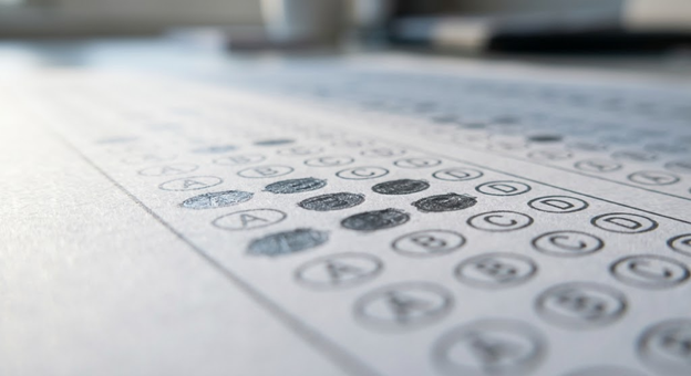 A multiple-choice answer sheet with a few bubbles filled in, photographed at a low angle