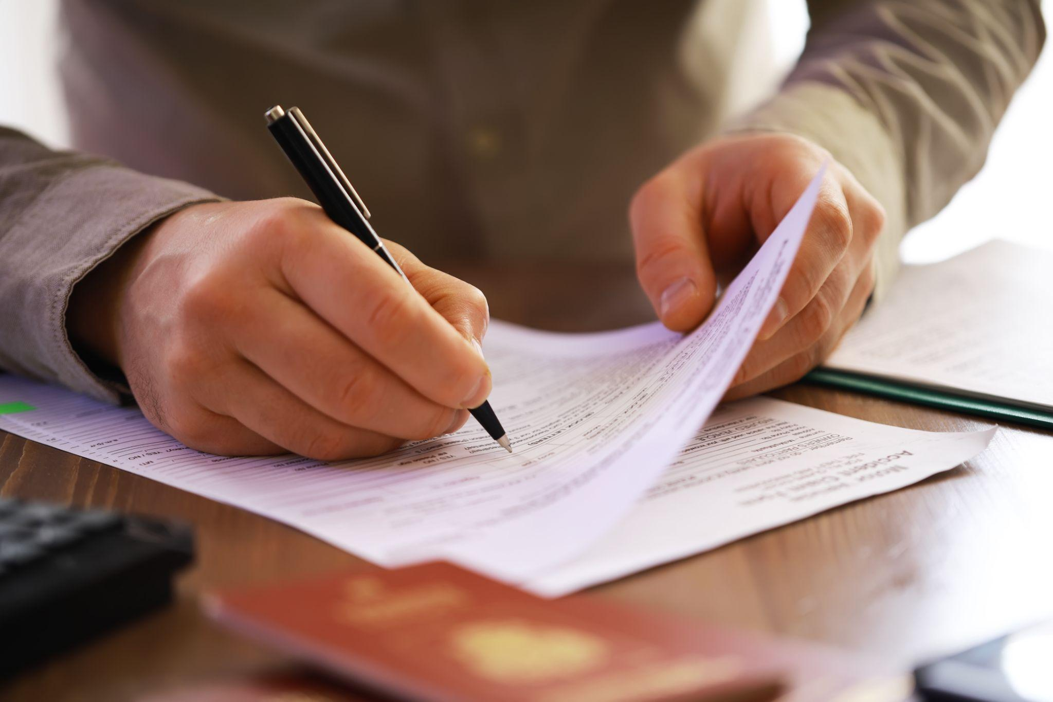 A person is completing an authorization form for employment verification background check.