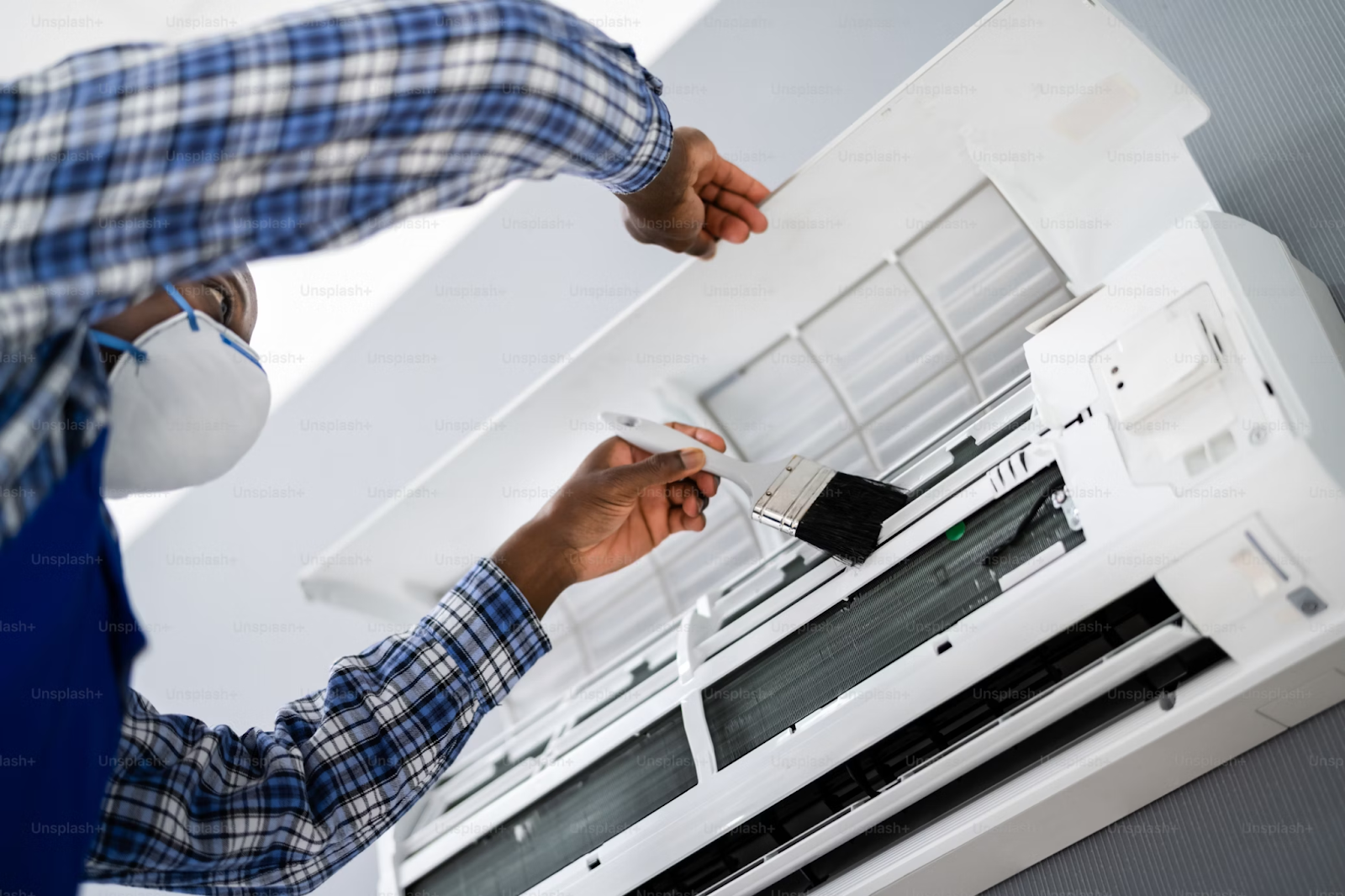 A person repairing an air conditioner