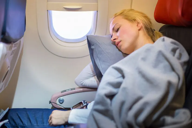 A woman sleeping on a plane