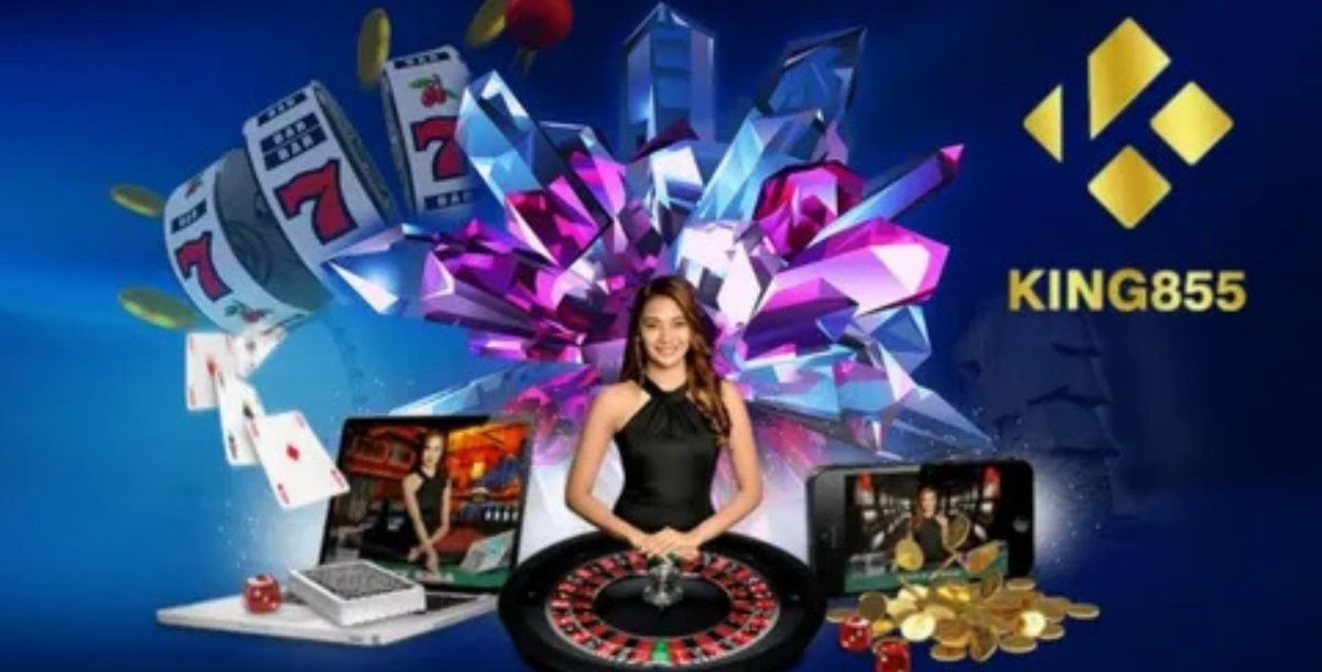 A woman standing behind a roulette wheel, surrounded by floating slot machine reels, gold coins, and large pink and purple crystal shapes.