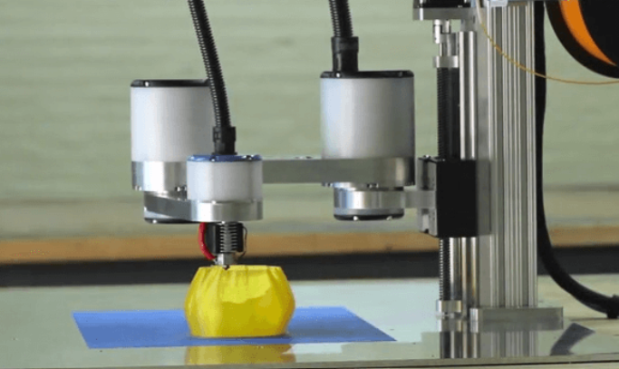A 3D printer creating a yellow object on a blue platform.