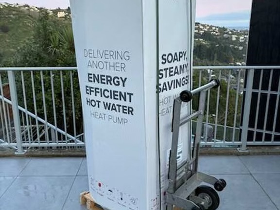 Photo of box saying delivering another energy efficient hot water heat pump on trolley
