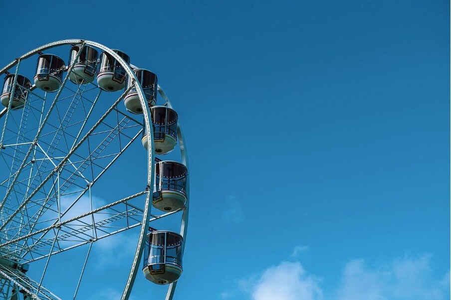 A cropped image of a ferris wheel against a blue sky