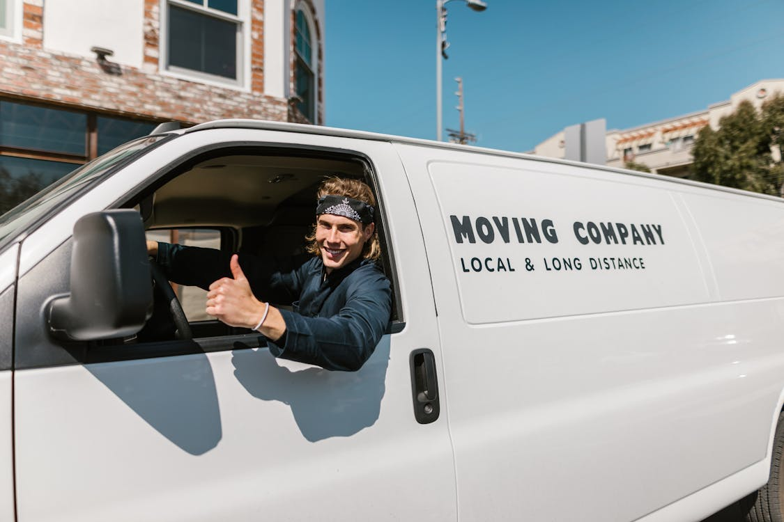 Man in Black Jacket Sitting on White Van