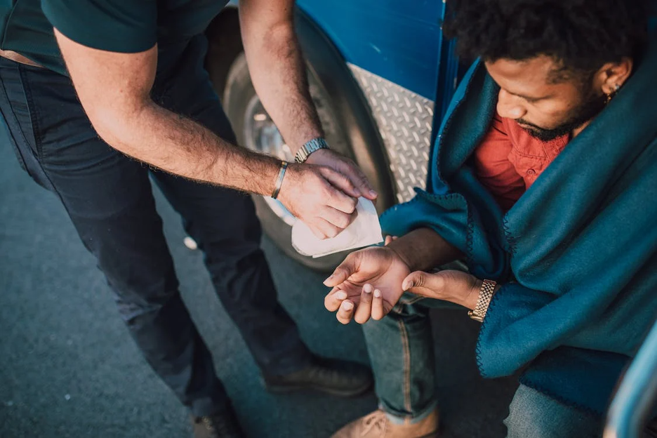 Photo of Person bandaging another person's hand