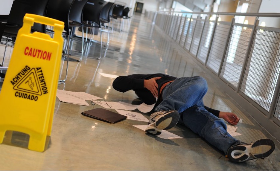 Concept image for Slip and Fall Lawyer - photo of person who has fallen near a caution sign