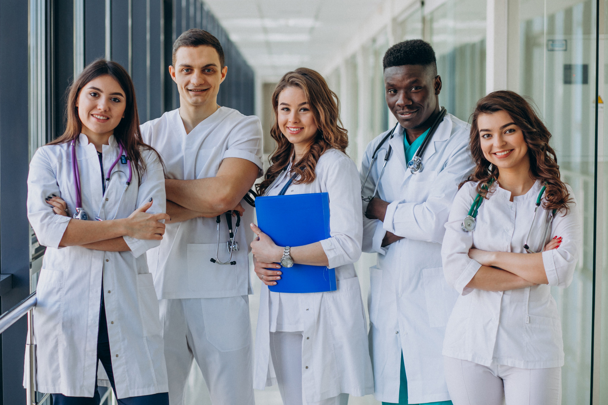 Team of young specialist doctors standing in the corridor of the hospital
