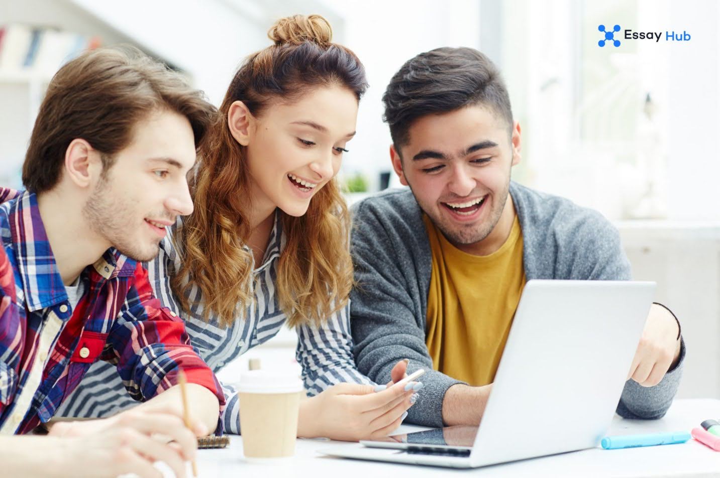 three people having a discussion in front of a laptop
