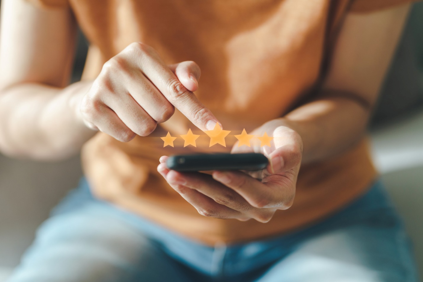 Close up of woman customer giving a five star rating on smartphone. Review, Service rating, satisfaction, Customer service experience and satisfaction survey concept.