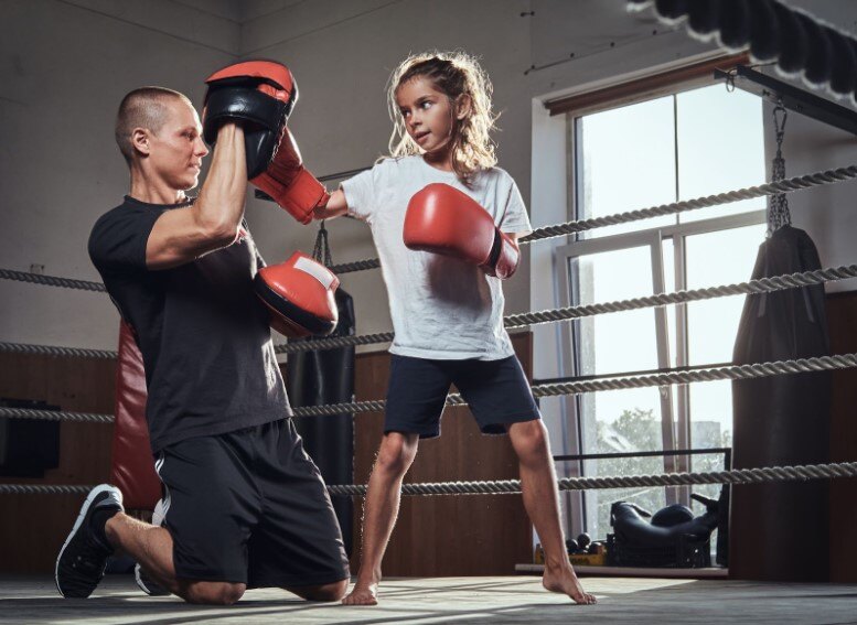 Boxing In Youth Culture: Young boxer is training with little girl boxer