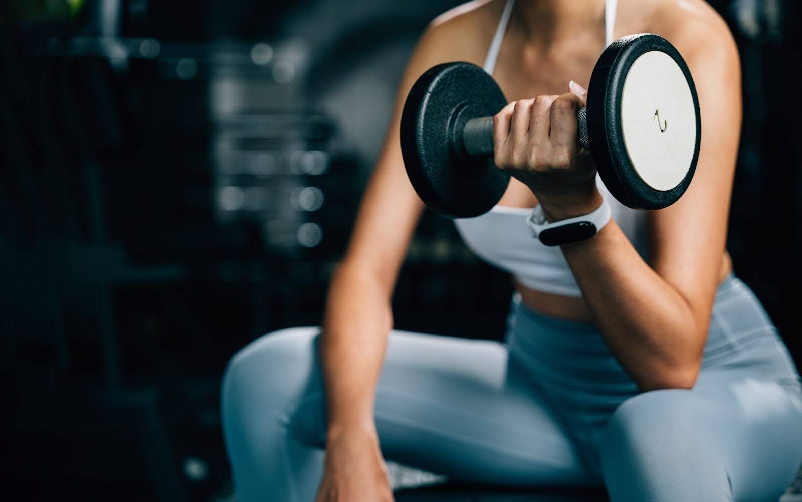 a close up of a woman holding a dumbell
