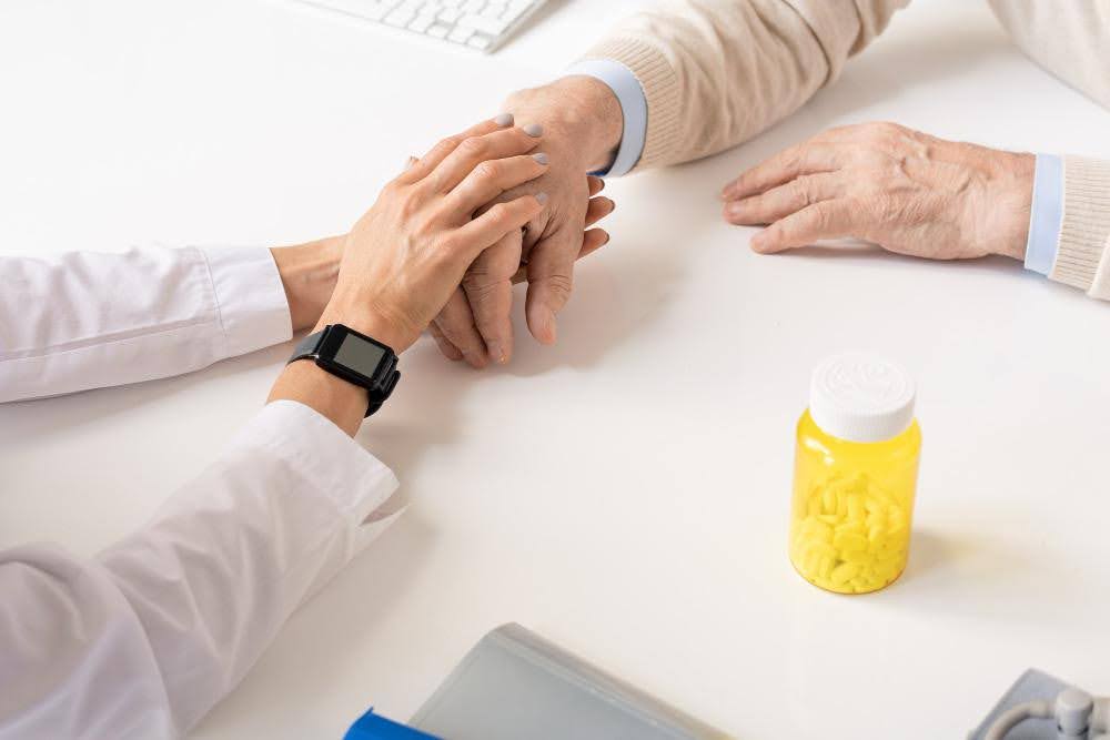 a doctor holding a patient hand in close up