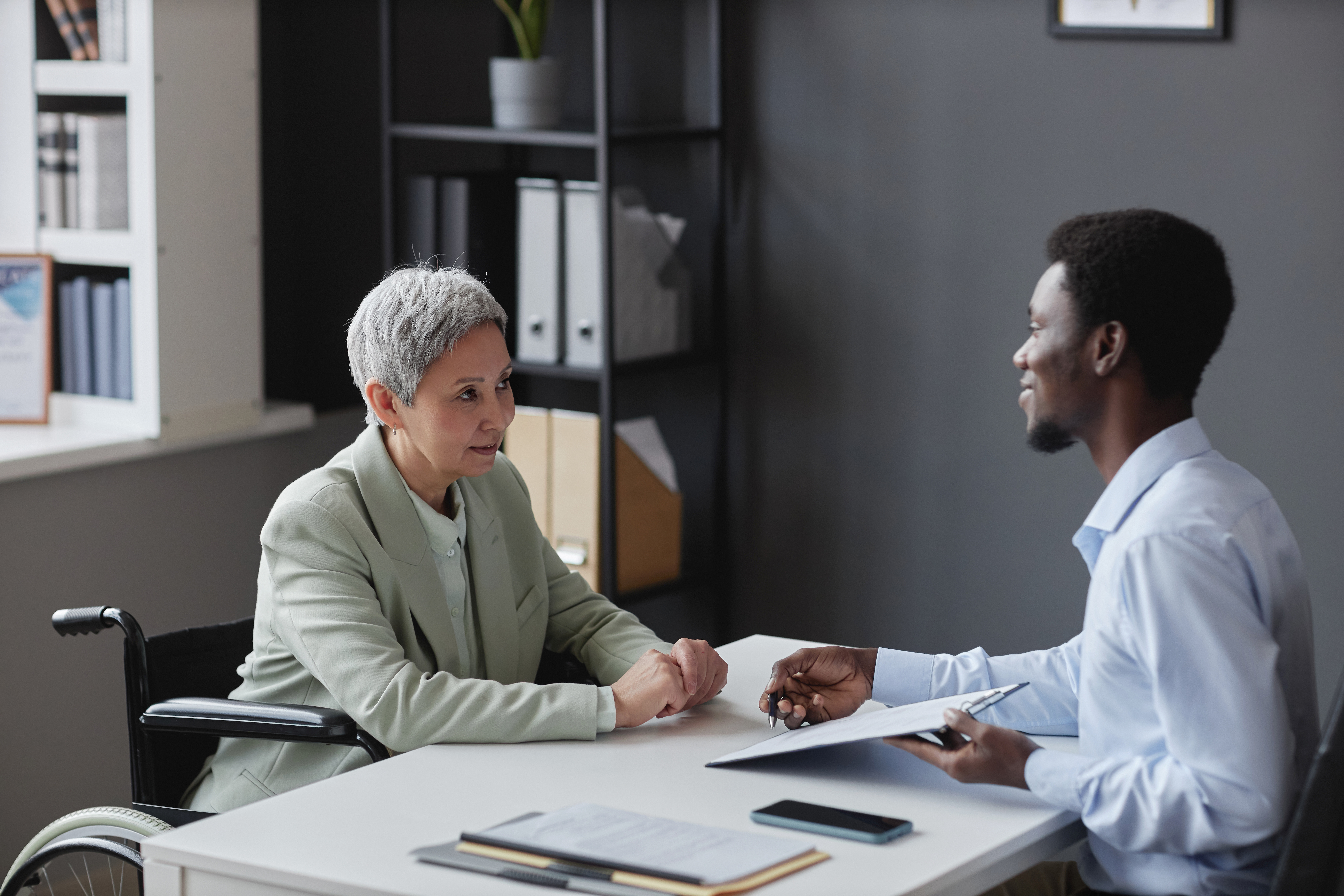 a man and a woman in a wheelchair in an office