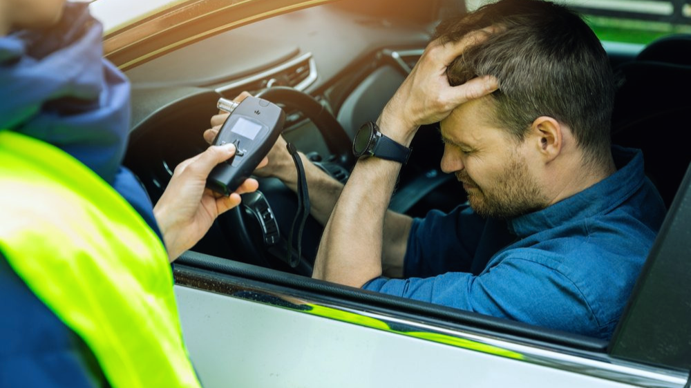 a man in a car getting pulled over by a police