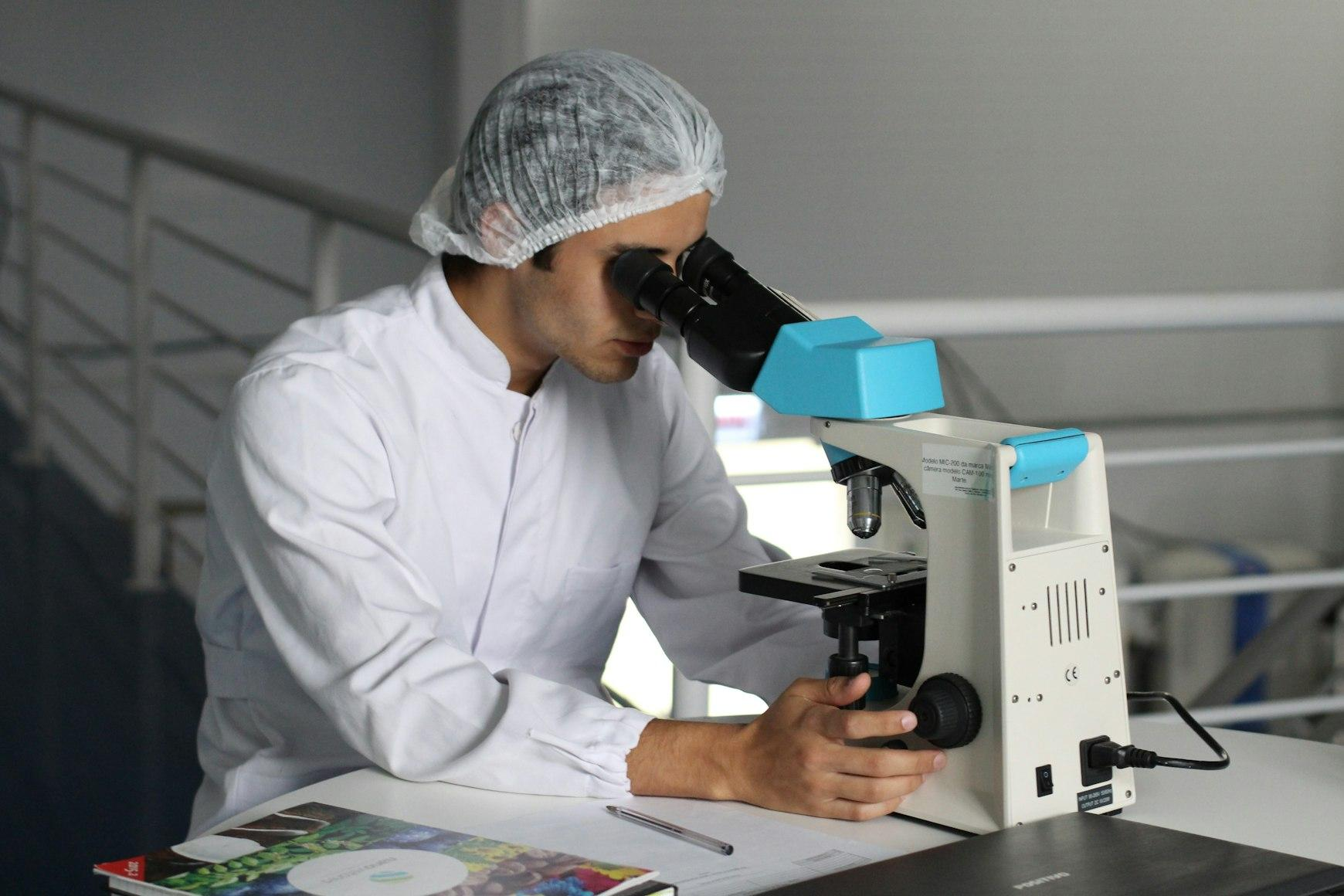 a man looking at a microscope