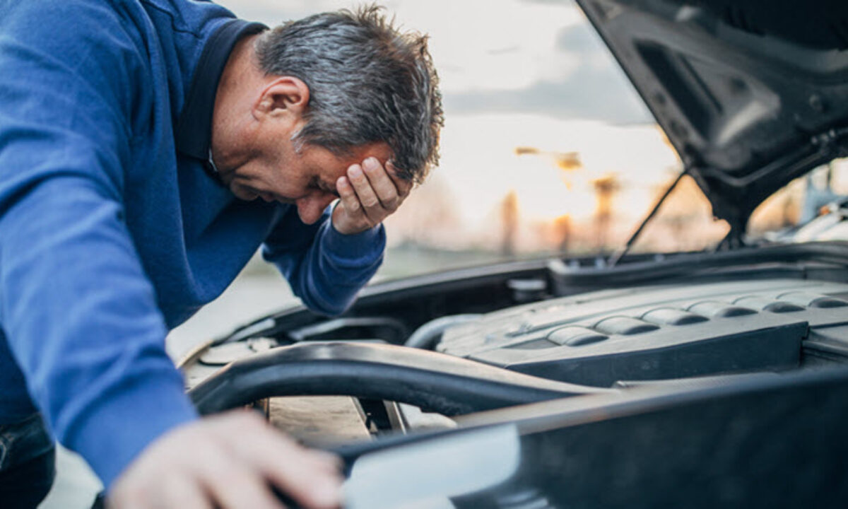 a man looks stressed in front of car engine