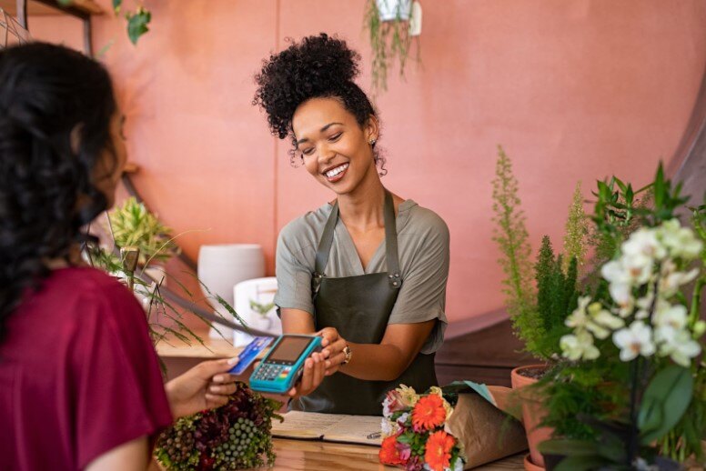a woman makes a payment using card in a flower shop