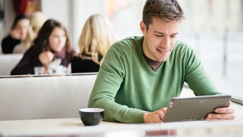 Photo of man in cafe using tablet