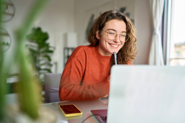 a women smiling in front of her computer screen