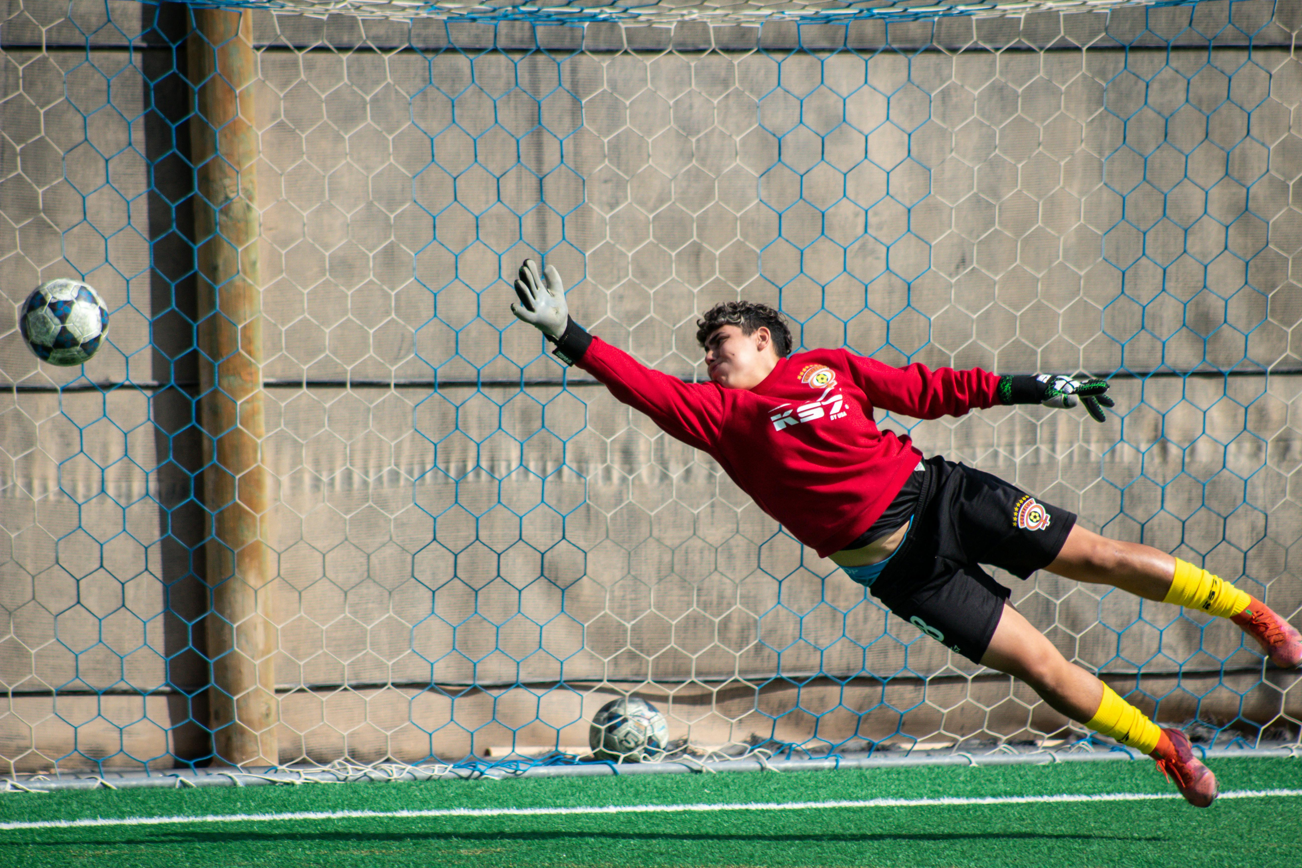 goalkeeper-leaping-to-save-soccer-ball-on-field