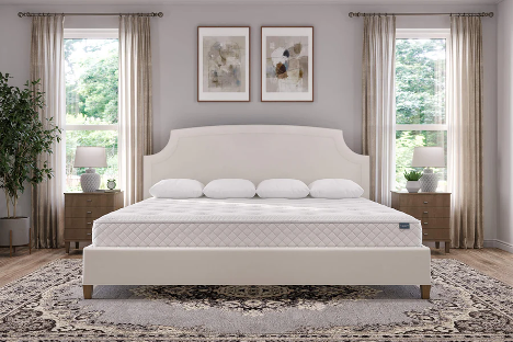 A large bed with new mattress in a luxurious and elegantly designed bedroom featuring warm grey tones