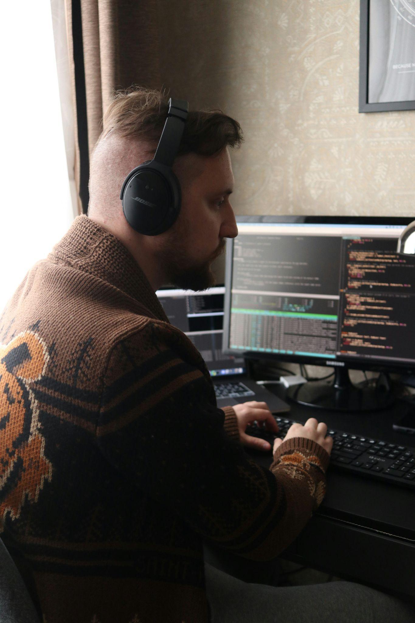 a man with a headphone in front of a computer