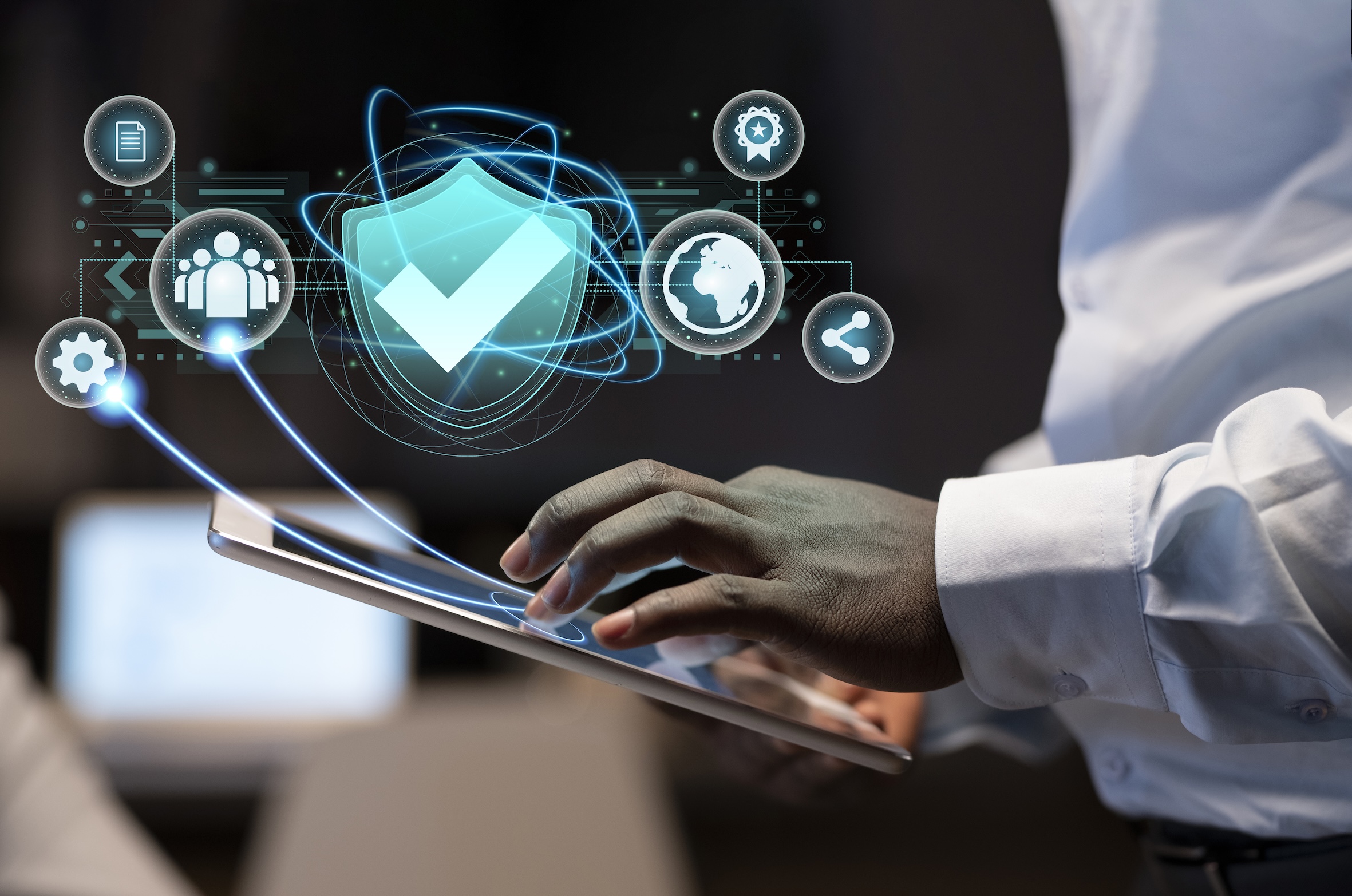 Person holding a tablet with icons imposed to be leaping off the screen implying security online