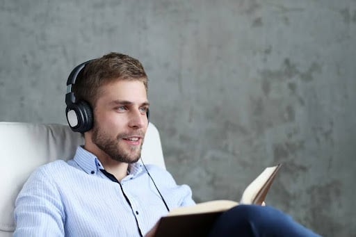 How to dive into fantasy books: image of a handsome man listening music headphones