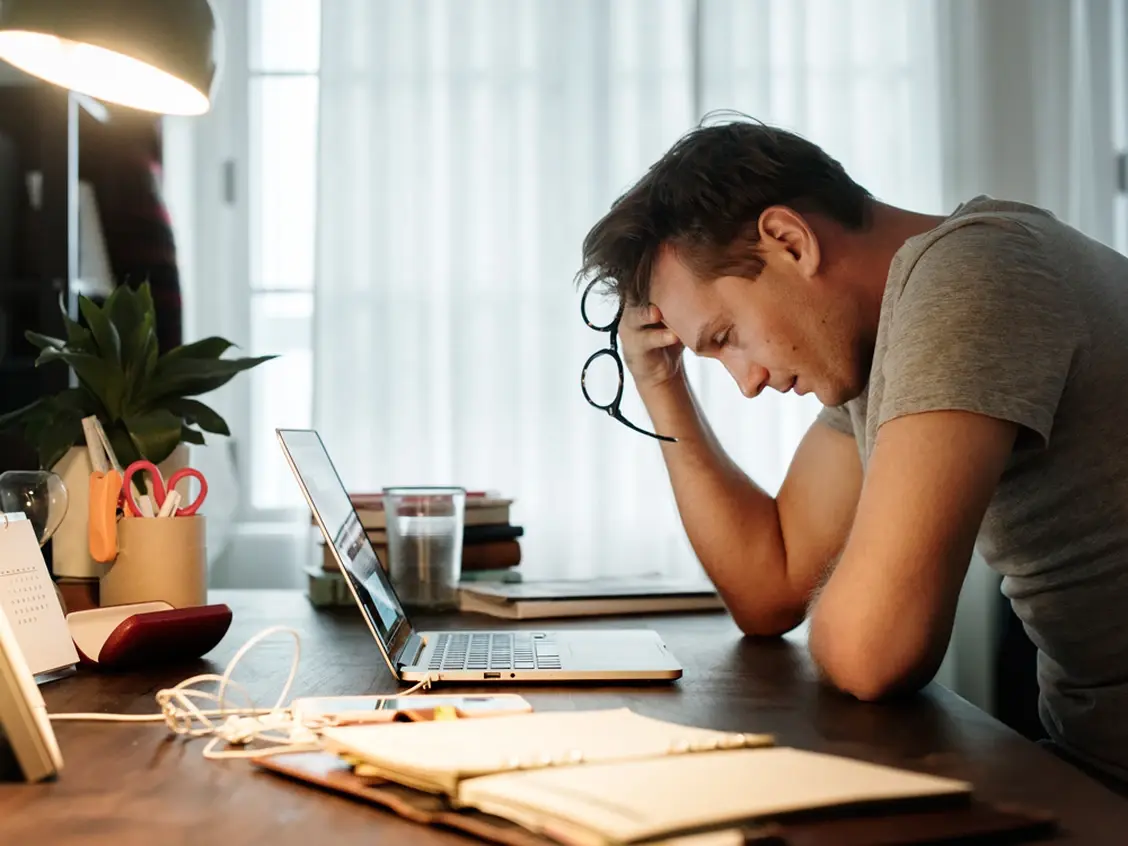 Man stressed while working on laptop